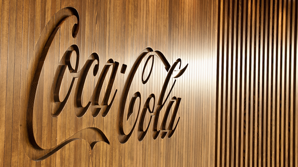 A wooden wall with the Coca-Cola logo carved in