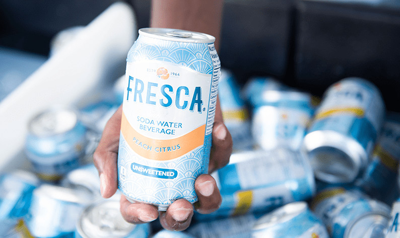 A hand holding a can of Fresca Sparkling Soda Water