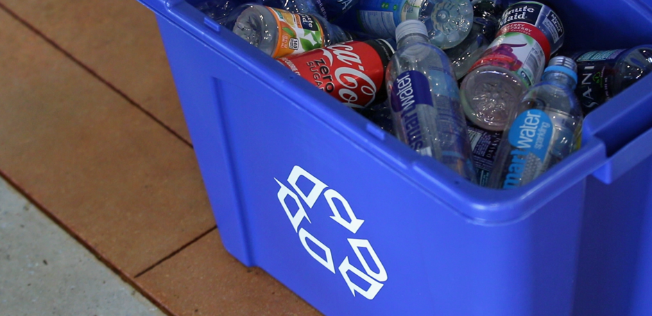 Blue recycling bin containing plastic bottles and cans